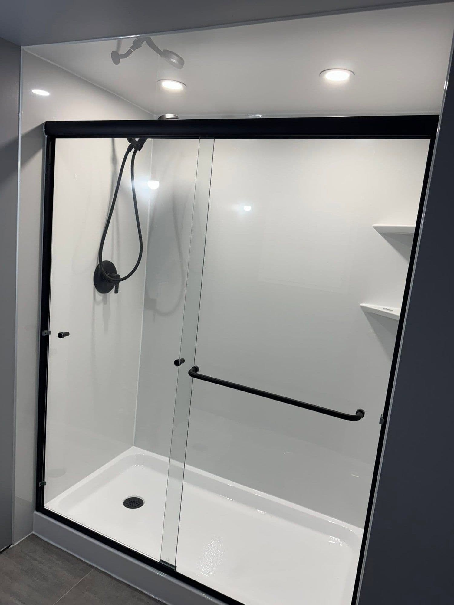 Renovated bathroom with a black-framed glass shower