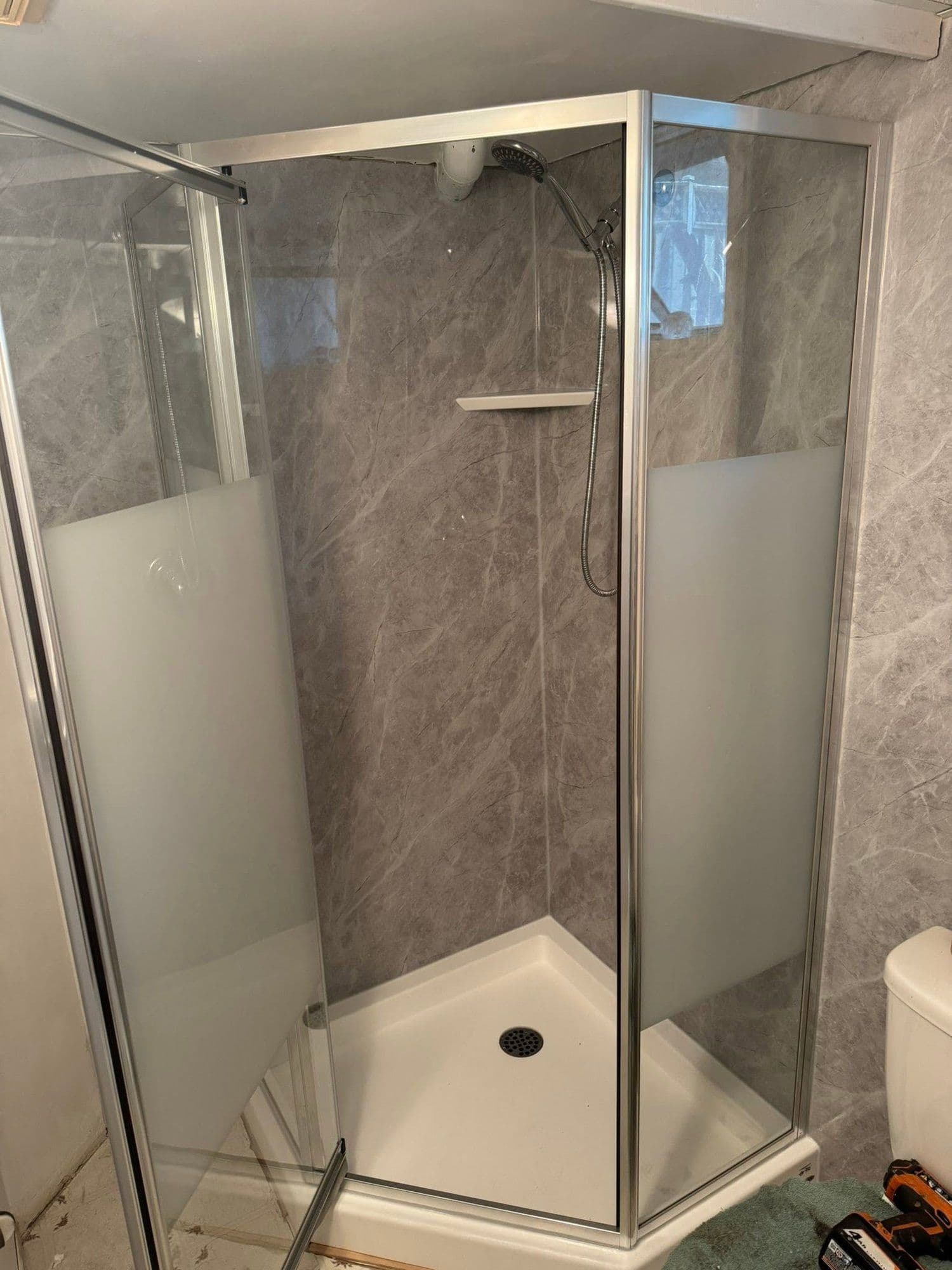 Finished bathroom with a grey marble-look corner shower