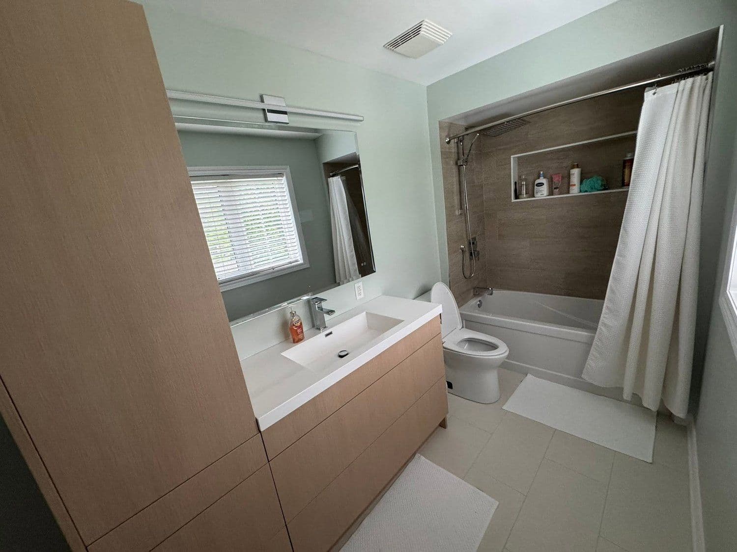 Powder room with a round mirror and dark vanity