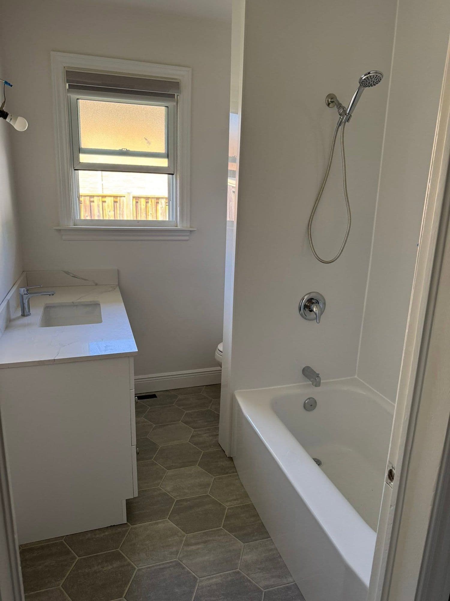 Bathroom with a marble-top vanity and hex tile floor